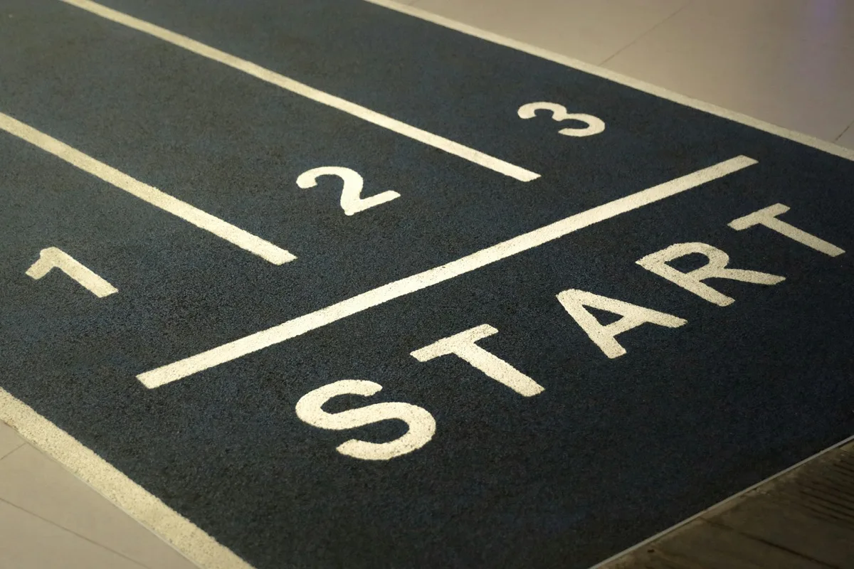 Running track start line representing the beginning of a personal training business journey